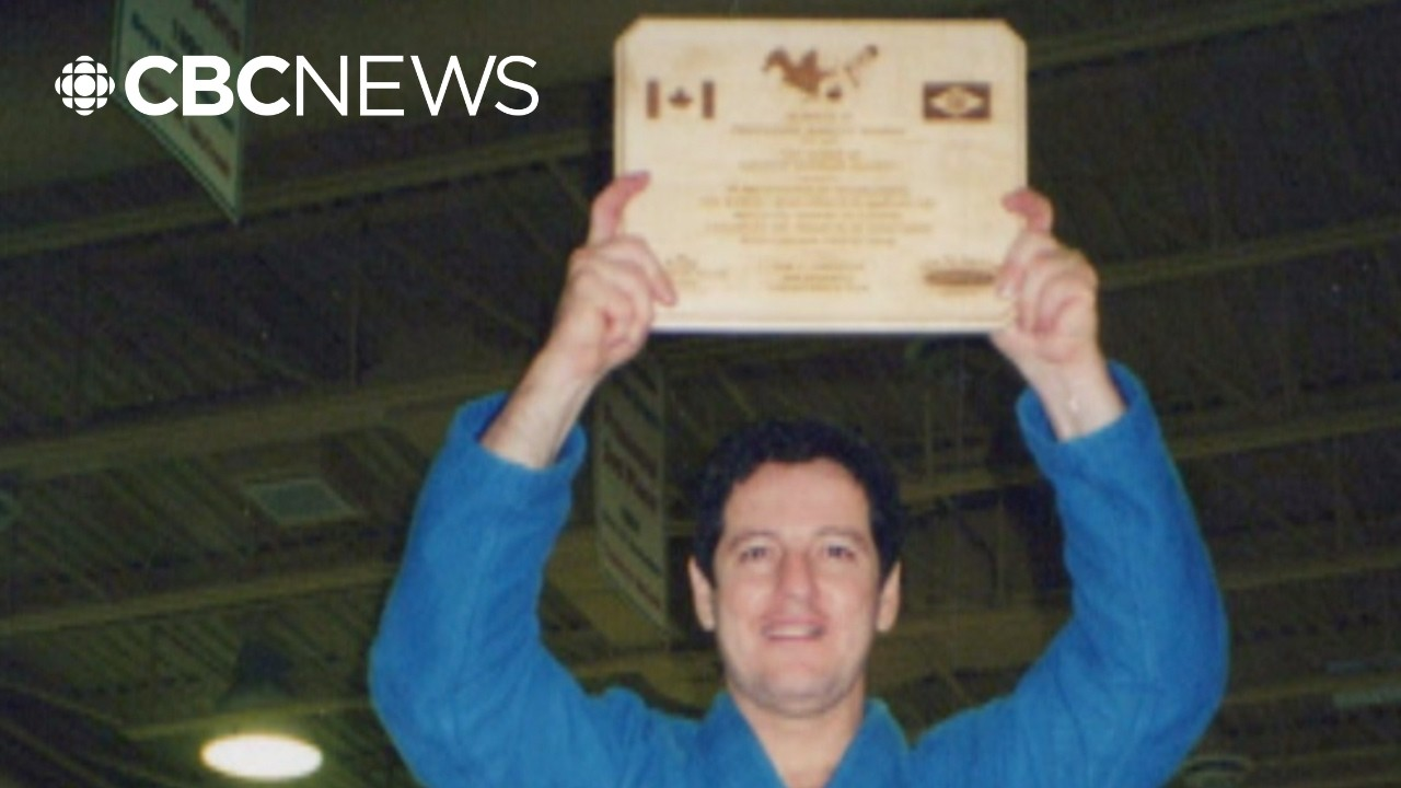CBC News image of Marcus in a blue jiu-jitsu gi holding a certificate above his head